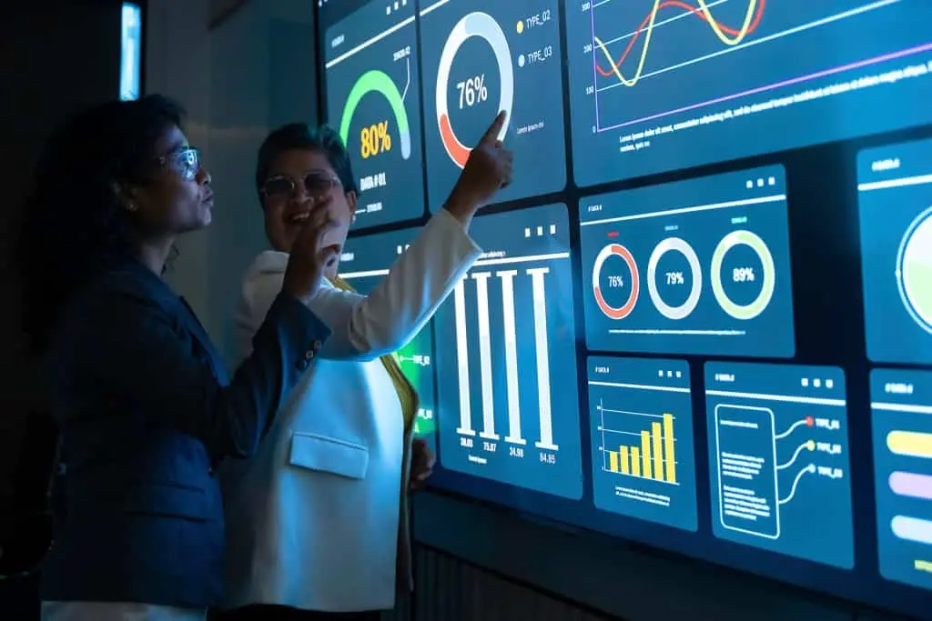 Consultores analizando dashboards de datos en pantalla futurista