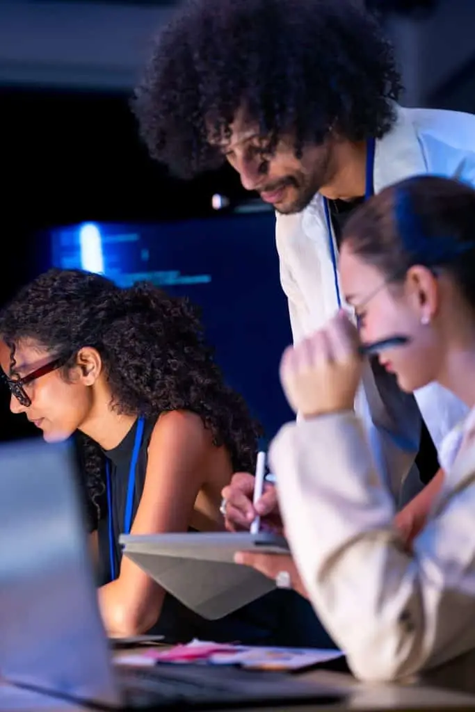 Equipo de software diverso colaborando alrededor de una laptop